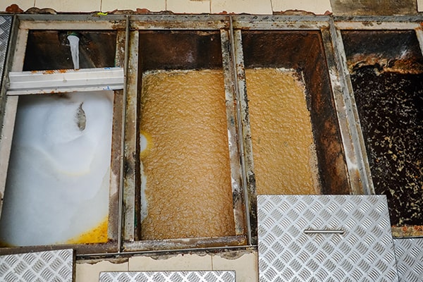 during grease trap maintenance, the trap is emptied, cleaned, and inspected to remove built-up grease and prevent blockages